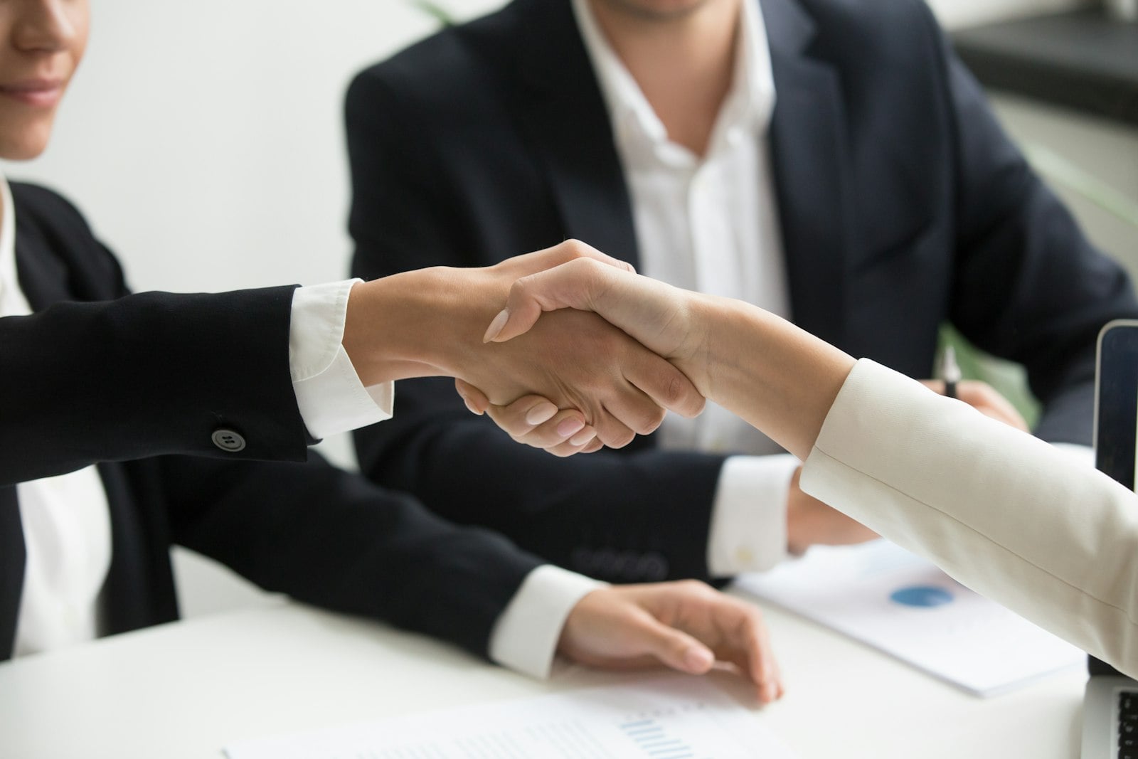 Professional welcoming a new client and reviewing intake materials.