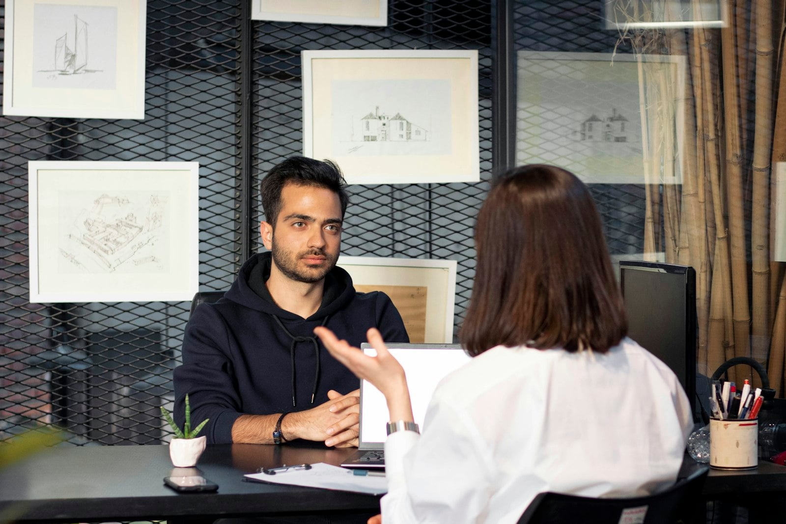 Hiring team reviewing a role and interview schedule; fictional data only.