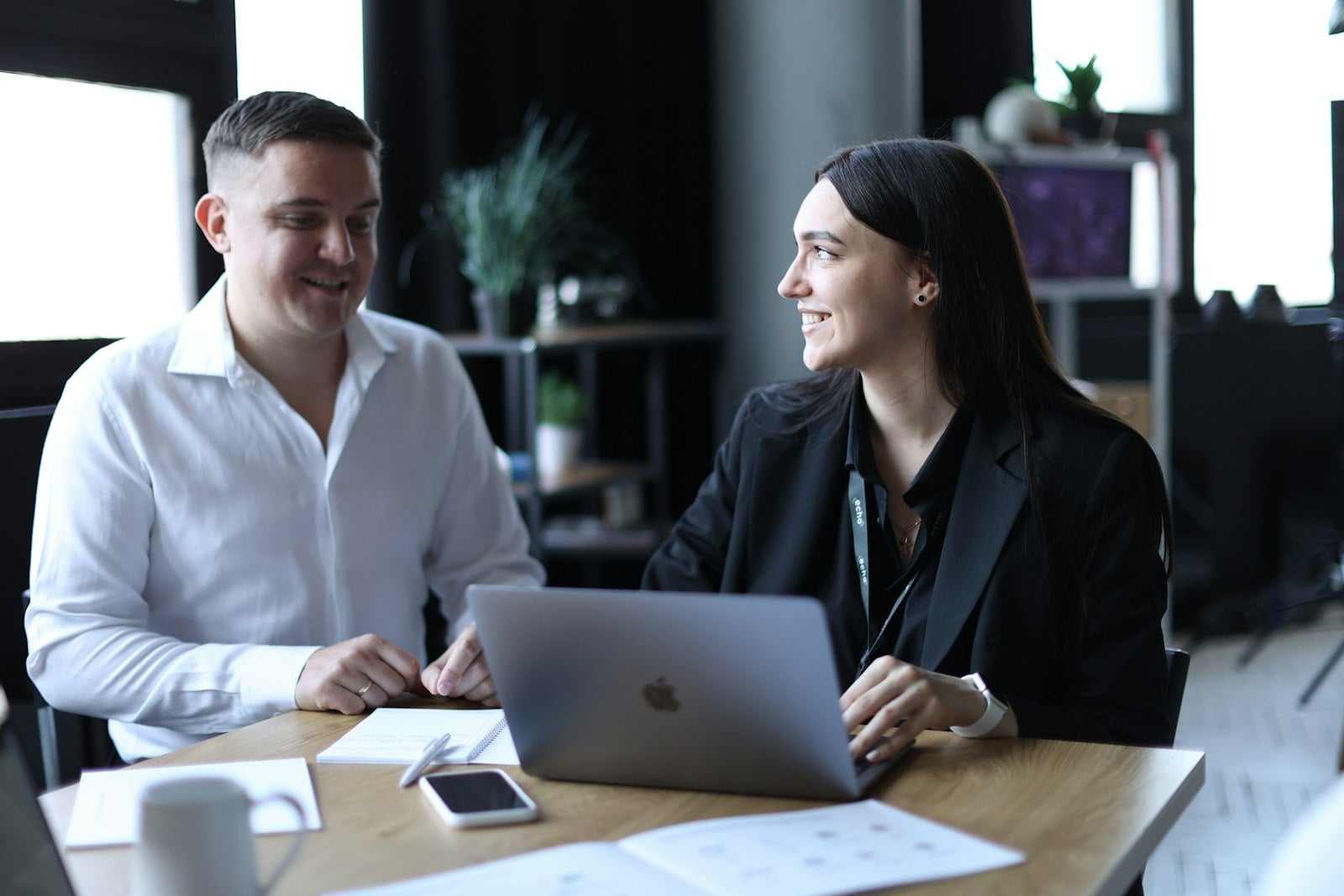 Two colleagues talking over a laptop
