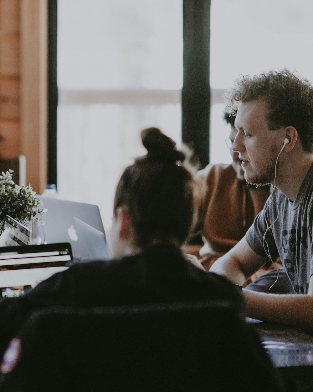 A team member working with a colleague at a shared table