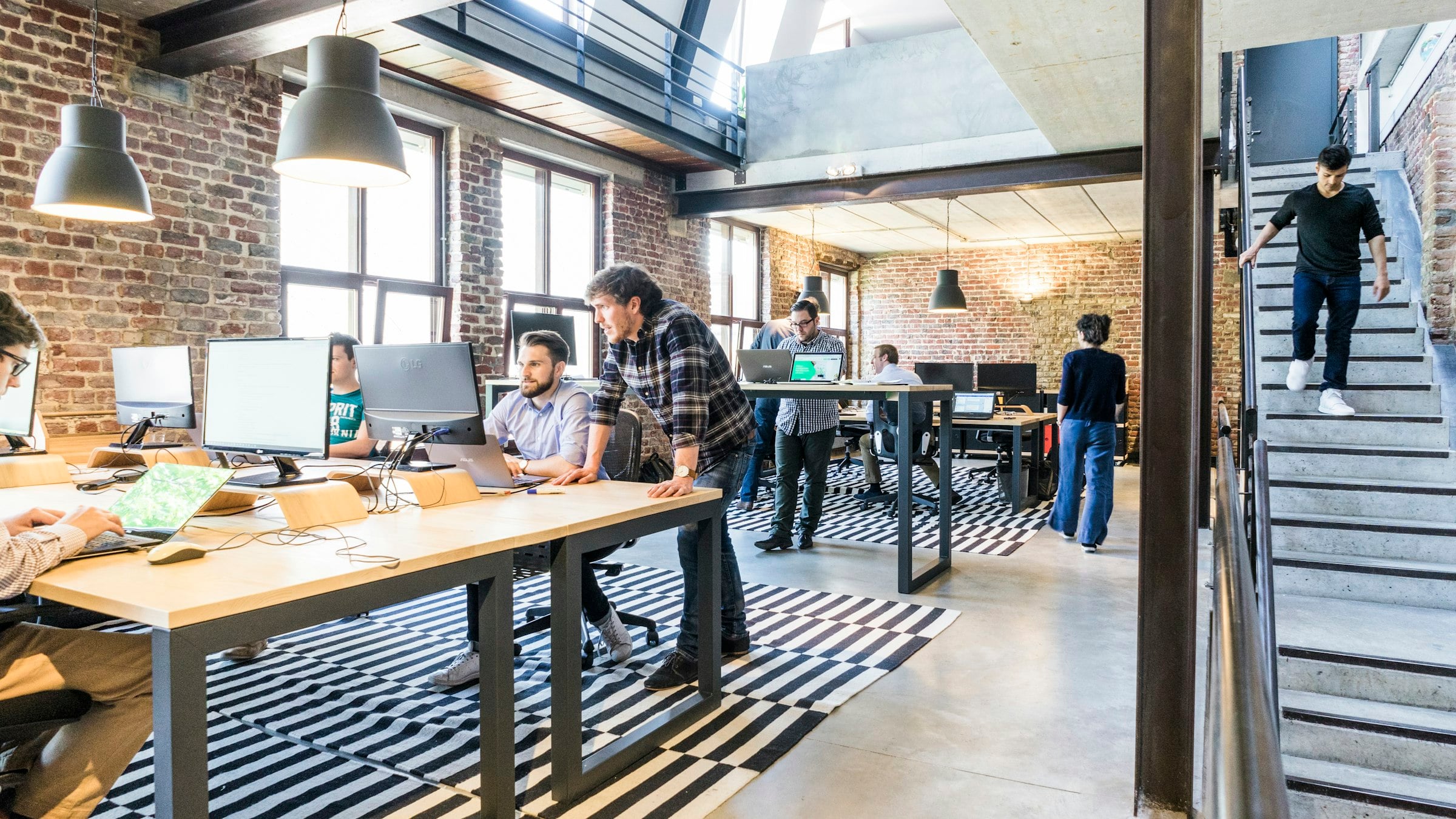 A bright open office, two colleagues working through a plan at a desk
