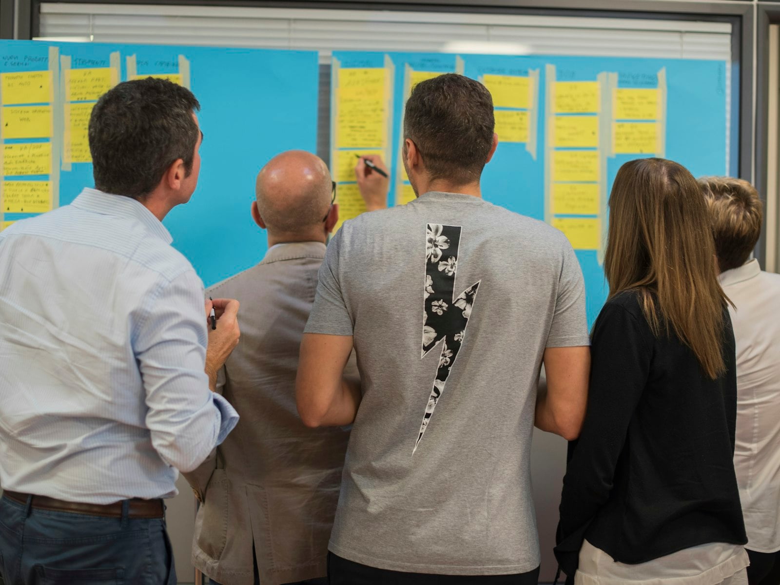A team working through plans on a wall of notes
