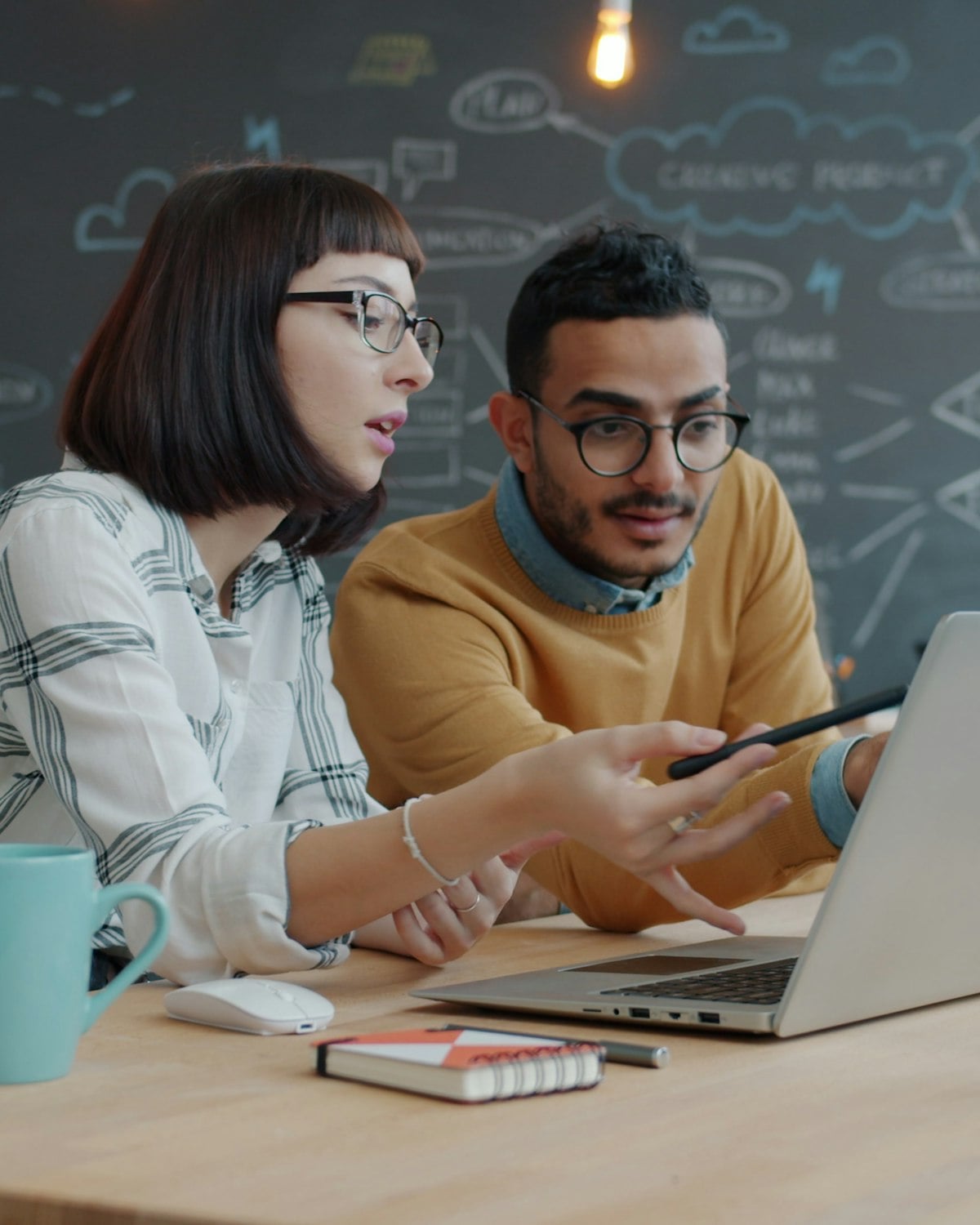Two colleagues working through a plan on a laptop
